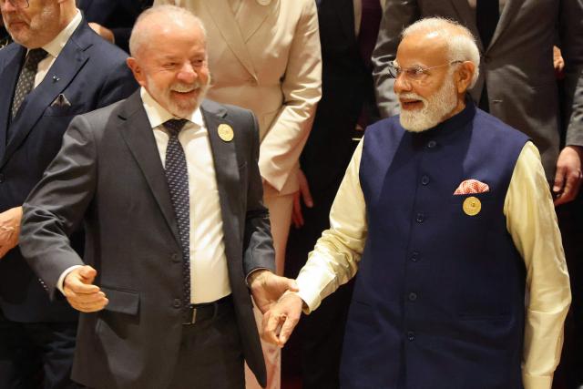 Brazil's President Luiz Inacio Lula da Silva (L) and India's Prime Minister Narendra Modi  leave after a group photo while attending the AI Impact Summit in New Delhi on February 19, 2026. (Photo by Ludovic MARIN / AFP)