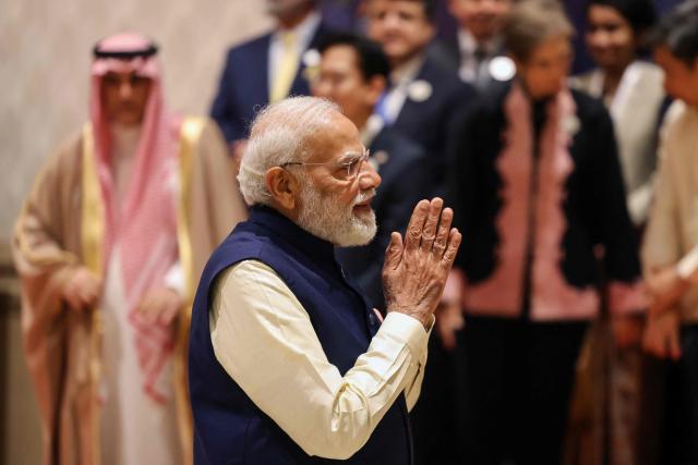 India's Prime Minister Narendra Modi gestures as he gathers with world leaders and representatives for a group photo during the AI Impact Summit in New Delhi on February 19, 2026. (Photo by Ludovic MARIN / AFP)
