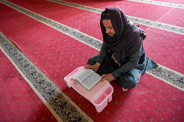 A madrassa student recites the Quran on the first day of Islamic holy fasting month of Ramadan, in Peshawar on February 19, 2026. (Photo by SUJIT JAISWAL / AFP)