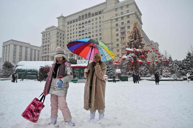 Tourists visit Moscow's Manezhnaya Sqaure during heavy snowfall on February 19, 2026. (Photo by HECTOR RETAMAL / AFP)