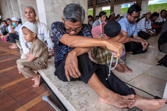 Muslim devotees gather to listen to a religious lecture while waiting to break their fast at Istiqlal Mosque in Jakarta on February 19, 2026, during the holy month of Ramadan, when Muslims worldwide abstain from food, drink and sexual relations from dawn to dusk. (Photo by BAY ISMOYO / AFP)