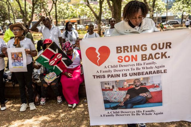 Relatives of Kenyan nationals conscripted by the Russian army in Ukraine pose with photos of their family members during a prayer and peaceful demonstration demanding urgent government action to repatriate their kin, in Nairobi on February 19, 2026. More than 1,000 Kenyans have gone to fight for the Russian army in Ukraine, most of them tricked into signing military contracts, according to an intelligence report presented to Kenya's parliament. (Photo by SIMON MAINA / AFP)