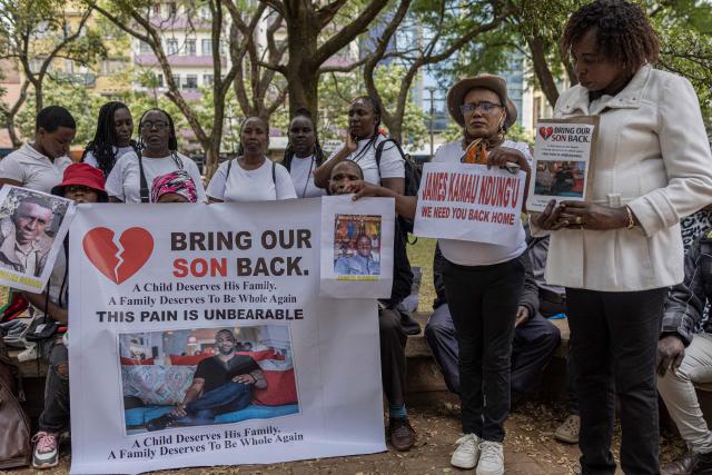 Relatives of Kenyan nationals conscripted by the Russian army in Ukraine pose with photos of their family members during a prayer and peaceful demonstration demanding urgent government action to repatriate their kin, in Nairobi on February 19, 2026. More than 1,000 Kenyans have gone to fight for the Russian army in Ukraine, most of them tricked into signing military contracts, according to an intelligence report presented to Kenya's parliament. (Photo by SIMON MAINA / AFP)