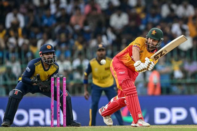 Zimbabwe's Ryan Burl (R) plays a shot as Sri Lanka's wicketkeeper Kusal Mendis watches during the 2026 ICC Men's T20 Cricket World Cup group stage match between Sri Lanka and Zimbabwe at the R Premadasa Stadium in Colombo on February 19, 2026. (Photo by Ishara S. KODIKARA / AFP)