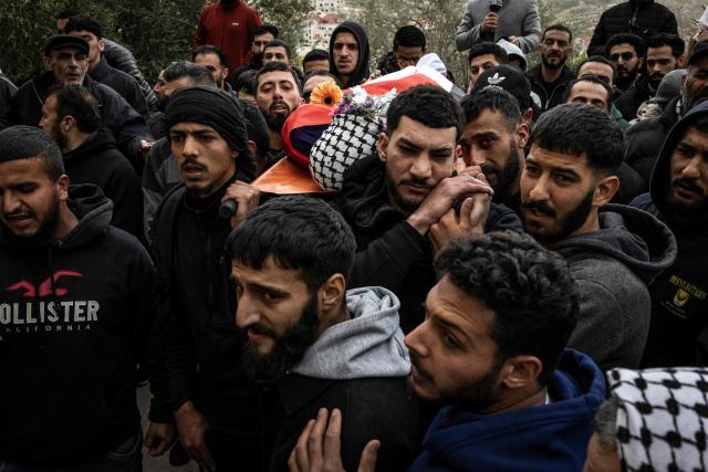 Friends and family carry the body of 19-year-old Nasrallah Mohammad Siam, during his funeral in Mikhams, in the Israeli-occupied West Bank on February 19, 2026, after he was killed the day before during a Israeli settler attack. Violence in the Palestinian West Bank, which Israel has occupied since 1967, has soared since the Hamas attack on Israel triggered the Gaza war in October 2023. (Photo by JOHN WESSELS / AFP)