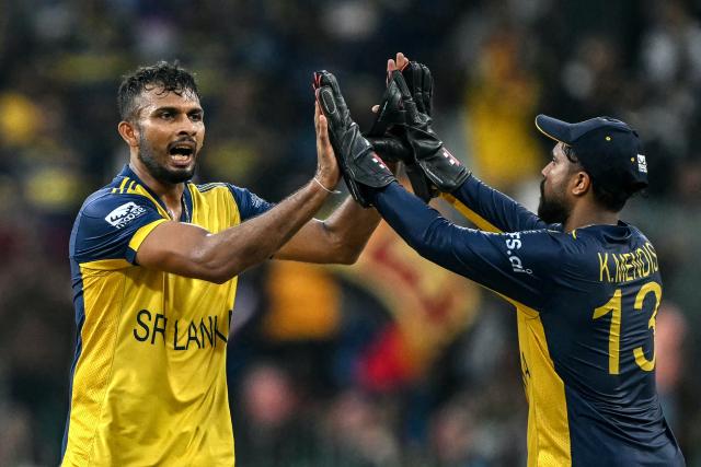 Sri Lanka's captain Dasun Shanaka (L) celebrates with teammate Kusal Mendis after taking the wicket of Zimbabwe's Ryan Burl during the 2026 ICC Men's T20 Cricket World Cup group stage match between Sri Lanka and Zimbabwe at the R Premadasa Stadium in Colombo on February 19, 2026. (Photo by Ishara S. KODIKARA / AFP)