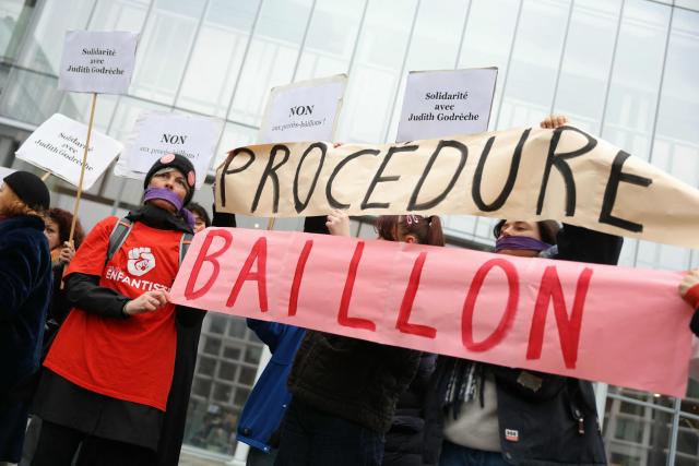 Women hold a banner which reads as "Procedure - gag" as they gather outside the Paris courthouse in support of French actress Judith Godreche in Paris on February 19, 2026. Judith Godrèche, a leading figure of #MeToo in France, has been summoned on February 19 for a procedural hearing before the Paris court, following a defamation complaint by filmmaker Jacques Doillon, whom she accuses of raping her when she was 15. (Photo by Thomas SAMSON / AFP)