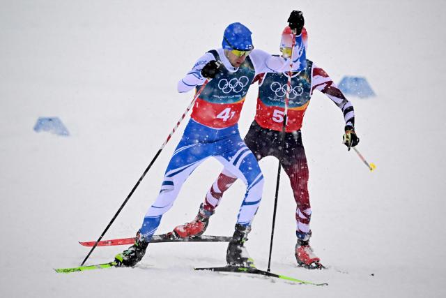 Finland's Ilkka Herola (L) and Austria's Stefan Rettenegger compete in the cross-country of the nordic combined team sprint large hill event at Tesero Cross Country Stadium at Lago di Tesero (Val di Fiemme) during the Milano Cortina 2026 Winter Olympic Games on February 19, 2026. (Photo by Tobias SCHWARZ / AFP)