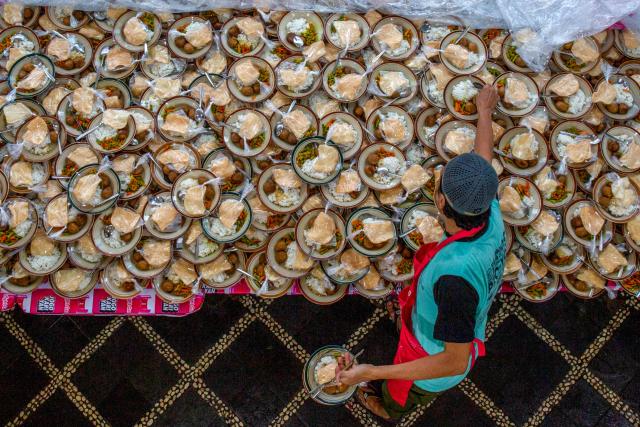 A worker prepares free iftar meals for Ramadan observers at the Jogokariyan Mosque in Yogyakarta on February 19, 2026. (Photo by Devi Rahman / AFP)