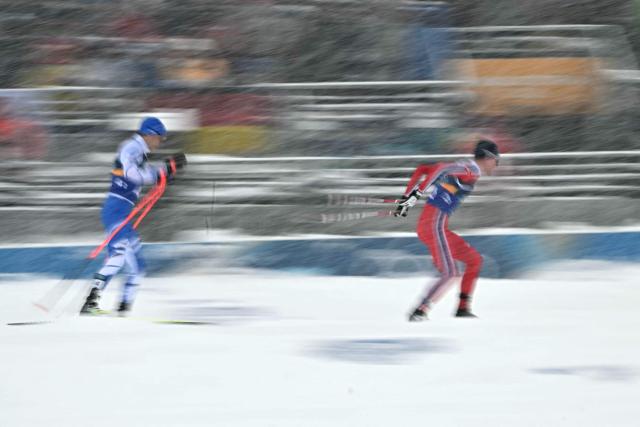 Finland's Eero Hirvonen (L) and Norway's Jens Luraas Oftebro compete in the cross-country of the nordic combined team sprint large hill event at Tesero Cross Country Stadium at Lago di Tesero (Val di Fiemme) during the Milano Cortina 2026 Winter Olympic Games on February 19, 2026. (Photo by Javier SORIANO / AFP)