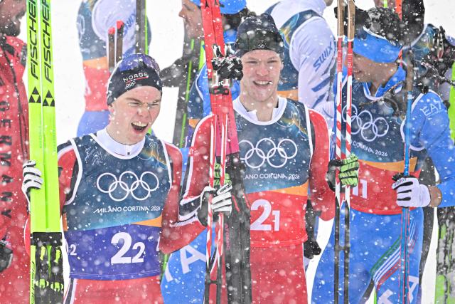 Gold medallists Norway's Jens Luraas Oftebro (L) and Norway's Andreas Skoglund celebrate at the end of the cross-country of the nordic combined team sprint large hill event at Tesero Cross Country Stadium at Lago di Tesero (Val di Fiemme) during the Milano Cortina 2026 Winter Olympic Games on February 19, 2026. (Photo by Tobias SCHWARZ / AFP)
