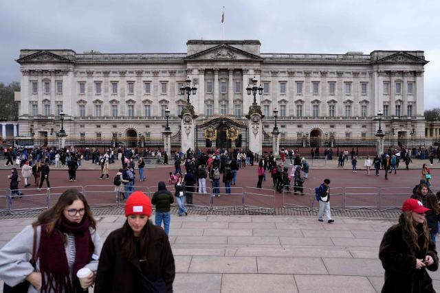 Tourists gather outside Buckingham Palace in London on February 19, 2026. Britain's former prince Andrew was arrested February 19, 2026 on suspicion of misconduct, with King Charles III saying in a statement "the law must take its course". The arrest follows new revelations last week that appeared to show Andrew sent convicted US sex offender Epstein potentially confidential documents during his time as a UK trade envoy. (Photo by CARLOS JASSO / AFP)