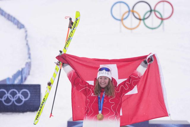 Gold medallist Switzerland's Marianne Fatton celebrates on the podium after competing in the women's sprint ski mountaineering event during the Milano Cortina 2026 Winter Olympic Games at the Stelvio Ski Centre in Bormio (Valtellina) on February 19, 2026. (Photo by Dimitar DILKOFF / AFP)