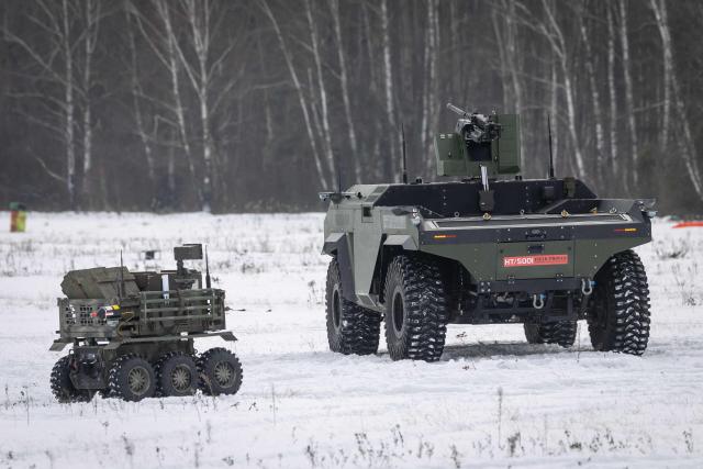 A Polish-made Unmanned Ground Vehicle PIAP HUNTeR (R) is pictured during an open test of unmanned weapon systems conducted by the Polish Armaments Group (Polska Grupa Zbrojeniowa) at the Military Institute of Armament Technology training ground in Zielonka, Warsaw suburbia, on February 19, 2026. (Photo by Wojtek RADWANSKI / AFP)