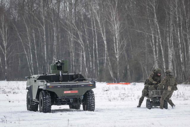 A Polish-made Unmanned Ground Vehicle PIAP HUNTeR (L) is pictured during an open test of unmanned weapon systems conducted by the Polish Armaments Group (Polska Grupa Zbrojeniowa) at the Military Institute of Armament Technology training ground in Zielonka, Warsaw suburbia, on February 19, 2026. (Photo by Wojtek RADWANSKI / AFP)