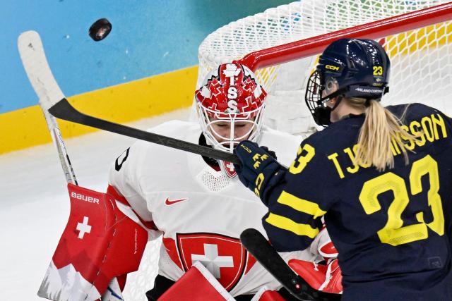 Sweden's #07 Mira Jungaker (R) scores her team's first goal against Switzerland's #20 Andrea Braendli (L) during the women's bronze medal ice hockey match between Switzerland and Sweden at the Milano Santagiulia Ice Hockey Arena during the Milano Cortina 2026 Winter Olympic Games in Milan, on February 19, 2026. (Photo by Alexander NEMENOV / AFP)