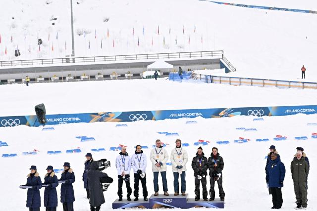 (From centre L) Silver medalist Finland's Ilkka Herola and Finland's Eero Hirvonen, gold medallist Norway's Jens Luraas Oftebro, Norway's Andreas Skoglund, and bronze medallist Austria's Johannes Lamparter and Austria's Stefan Rettenegger celebrate on the podium following the nordic combined team sprint large hill event at Tesero Cross Country Stadium at Lago di Tesero (Val di Fiemme) during the Milano Cortina 2026 Winter Olympic Games on February 19, 2026.  (Photo by Javier SORIANO / AFP)
