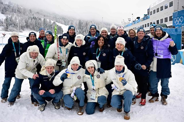 (From L) Gold medallist Norway's Jens Luraas Oftebro (centre Bottom L) and Norway's Andreas Skoglund (bottom R) celebrate with staff, teammates and Norway's Einar Luraas Oftebro (2ndL bottom) following the nordic combined team sprint large hill event at Tesero Cross Country Stadium at Lago di Tesero (Val di Fiemme) during the Milano Cortina 2026 Winter Olympic Games on February 19, 2026.  (Photo by Tobias SCHWARZ / AFP)
