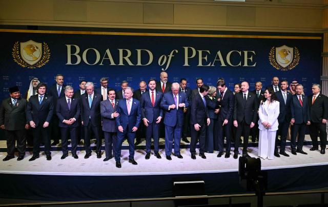 US President Donald Trump (C), flanked by US Vice President JD Vance (L) and US Secretary of State Marco Rubio (R), joins leaders for a group photo during the inaugural meeting of the "Board of Peace" at the US Institute of Peace in Washington, DC, on February 19, 2026. President Trump on Thursday gathers allies to inaugurate the "Board of Peace," his new institution focused on progress on Gaza but whose ambitions reach much further. Around two dozen world leaders or other senior officials have come to Washington for the meeting -- including several of Trump's authoritarian-leaning friends and virtually none of the European democrats that traditionally sign on to US initiatives. (Photo by SAUL LOEB / AFP)