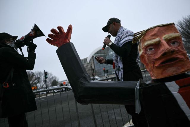 Demonstrators protest outside of the US Institute of Peace as President Donald Trump hosts the inaugural meeting of the "Board of Peace" at the in Washington, DC, on February 19, 2026. President Trump on Thursday gathers allies to inaugurate the "Board of Peace," his new institution focused on progress on Gaza but whose ambitions reach much further. Around two dozen world leaders or other senior officials have come to Washington for the meeting -- including several of Trump's authoritarian-leaning friends and virtually none of the European democrats that traditionally sign on to US initiatives. (Photo by Brendan SMIALOWSKI / AFP)