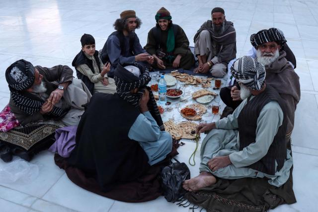 Muslim devotees wait to break their fast on the first day of the Islamic holy month of Ramadan at Jami Masjid, also known as the Great Mosque of Herat in Herat on February 19, 2026. (Photo by Mohsen KARIMI / AFP)