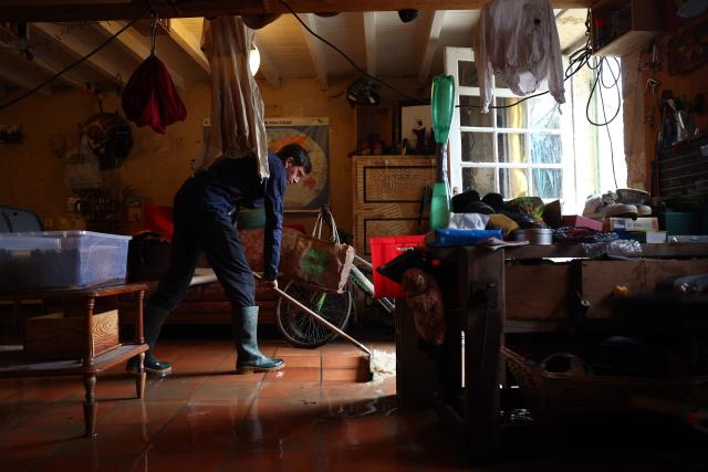 TOPSHOT - A man pushes flood water out of his house following heavy rain and flooding of the Garonne river in Langoiran, western France, on February 19, 2026, as the region braces with the risk of further flooding as Storm Pedro approaches. Four departments in western France were placed under red alert over the risk of flooding, with officials expecting the situation to worsen with the arrival of Storm Pedro, which is poised to batter swathes of western Europe. (Photo by ROMAIN PERROCHEAU / AFP)