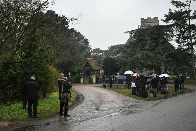 Police (far L and C behind) stand at an entrance to Wood Farm on the royal family's Sandringham Estate as members of the media (R) wait in Norfolk, eastern England on February 19, 2026, where former prince Andrew was arrested earlier in the day. Britain's royal family was in crisis on February 19 as former prince Andrew was in police custody after being arrested on suspicion of misconduct for his links to late US sex offender Jeffrey Epstein. (Photo by JUSTIN TALLIS / AFP)