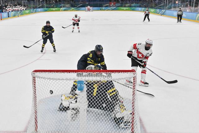 Switzerland's #25 Alina Muller (R) scores the winning goal  during the women's bronze medal ice hockey match between Switzerland and Sweden at the Milano Santagiulia Ice Hockey Arena during the Milano Cortina 2026 Winter Olympic Games in Milan, on February 19, 2026. (Photo by Alexander NEMENOV / POOL / AFP)