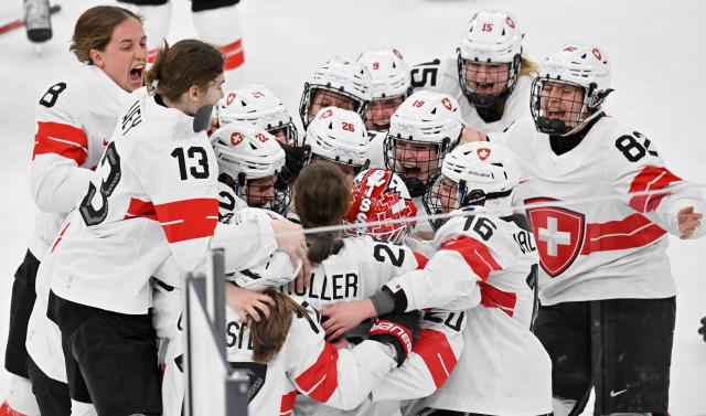 Switzerland's players celebrate the team's 3-2 win of the women's bronze medal ice hockey match between Switzerland and Sweden at the Milano Santagiulia Ice Hockey Arena during the Milano Cortina 2026 Winter Olympic Games in Milan, on February 19, 2026. (Photo by Alexander NEMENOV / AFP)