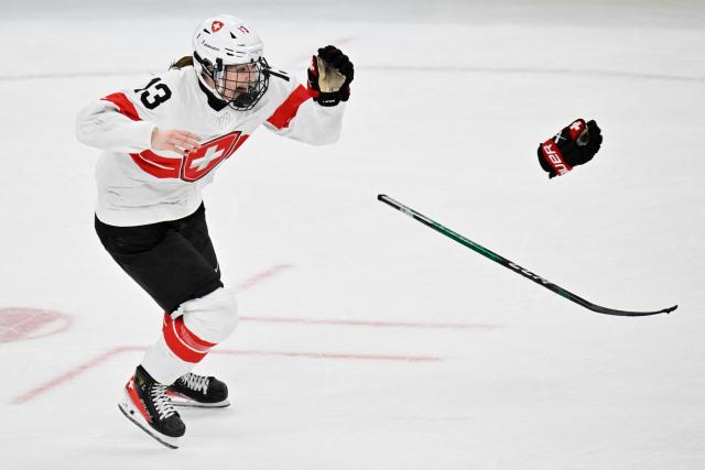 Switzerland's #13 Ivana Wey throws off gloves and stick as she celebrates the team's 3-2 win of the women's bronze medal ice hockey match between Switzerland and Sweden at the Milano Santagiulia Ice Hockey Arena during the Milano Cortina 2026 Winter Olympic Games in Milan, on February 19, 2026. (Photo by Alexander NEMENOV / AFP)