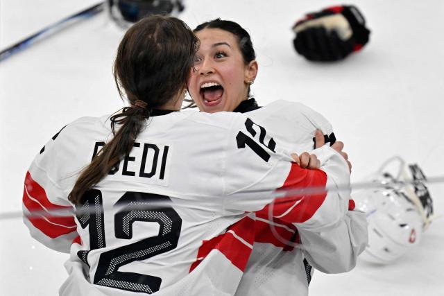Switzerland's #53 Vanessa Schaefer (R) and Switzerland's #12 Lisa Ruedi celebrate the team's 3-2 win of the women's bronze medal ice hockey match between Switzerland and Sweden at the Milano Santagiulia Ice Hockey Arena during the Milano Cortina 2026 Winter Olympic Games in Milan, on February 19, 2026. (Photo by Alexander NEMENOV / AFP)