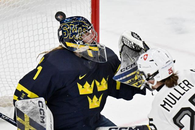 Sweden's #01 Ebba Svensson Traff (L) fails to save the goal from Switzerland's #25 Alina Muller (R) at the end of the women's bronze medal ice hockey match between Switzerland and Sweden at the Milano Santagiulia Ice Hockey Arena during the Milano Cortina 2026 Winter Olympic Games in Milan, on February 19, 2026. (Photo by Alexander NEMENOV / AFP)