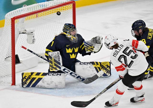 Sweden's #01 Ebba Svensson Traff (L) fails to save the goal from Switzerland's #25 Alina Muller (C) at the end of the women's bronze medal ice hockey match between Switzerland and Sweden at the Milano Santagiulia Ice Hockey Arena during the Milano Cortina 2026 Winter Olympic Games in Milan, on February 19, 2026. (Photo by Alexander NEMENOV / AFP)