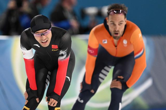 China's Ning Zhongyan (L) and Netherlands' Kjeld Nuis react after competing in the speed skating men's 1500m during the Milano Cortina 2026 Winter Olympic Games at Milano Speed Skating Stadium in Milan on February 19, 2026. (Photo by Daniel MUNOZ / AFP)