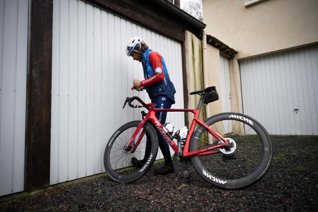 Groupama-FDJ's French cyclist Guillaume Martin-Guyonnet takes his bicycle from the parking at his home as he prepares for a training session in Dives-sur-mer, north-western france on February 19, 2026. French cyclist Guillaume Martin Guyonnet was the best climber in the 2020 Tour of Spain, came third in the Criterium du Dauphine the same year, and finished eighth in the 2021 Tour de France. He is also the author of several books on philosophy and its application to sport. (Photo by Lou BENOIST / AFP)