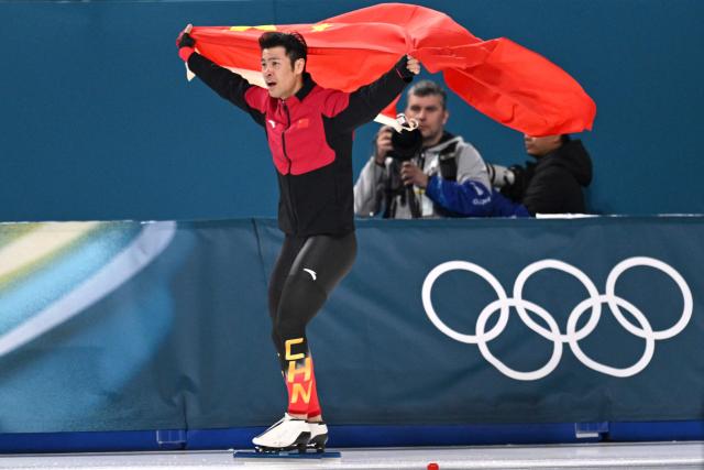 TOPSHOT - China's Ning Zhongyan waves his country's flag after winning gold in the speed skating men's 1500m during the Milano Cortina 2026 Winter Olympic Games at Milano Speed Skating Stadium in Milan on February 19, 2026. (Photo by Daniel MUNOZ / AFP)