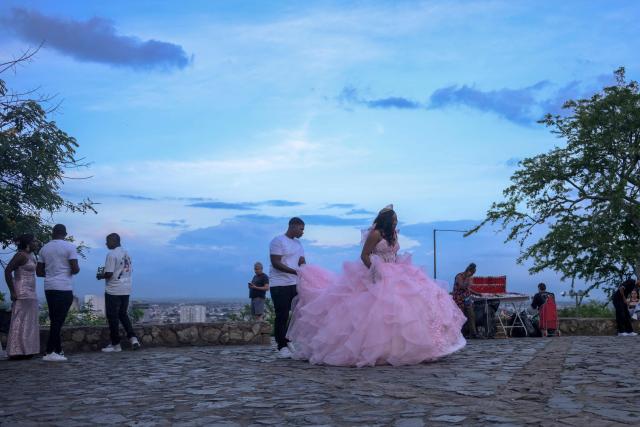 A girl in a dress prepares for a photo session as part of her 15th birthday celebration in the San Antonio neighbourhood in Cali, Colombia on February 16, 2026. The San Antonio neighborhood, known as the heart of "Old Cali", is a historic and bohemian area of colonial architecture, famous for its colorful facades and its location on a hill with panoramic views of the city. (Photo by Joaquín SARMIENTO / AFP)