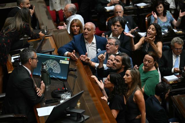 Opposition deputies argue with Argentine Chamber of Deputies President Martin Menem during a session to debate labor law reforms at the National Congress in Buenos Aires on February 19, 2026. The contested reforms pushed by Argentina's President Javier Milei would make it easier to hire and fire workers in a country where job security is already hard to come by. It would also reduce severance pay, limit the right to strike, increase work hours and restrict holiday provisions. (Photo by Luis ROBAYO / AFP)