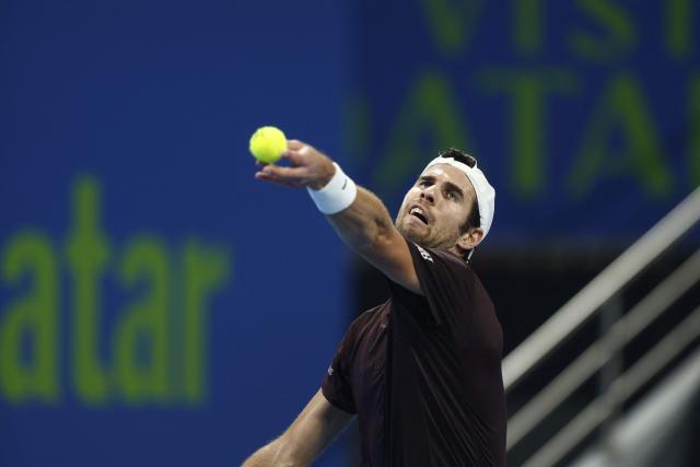 Russia's Karen Khachanov serves against Spain's Carlos Alcaraz during their men’s singles quarterfinal match at the Qatar Open tennis tournament in Doha on February 19, 2026. (Photo by Karim JAAFAR / AFP)