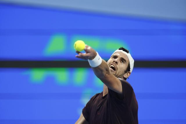 Russia's Karen Khachanov serves against Spain's Carlos Alcaraz during their men’s singles quarterfinal match at the Qatar Open tennis tournament in Doha on February 19, 2026. (Photo by Karim JAAFAR / AFP)