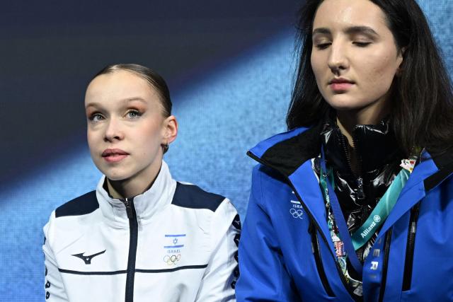 Israel's Mariia Seniuk (L) reacts in the kiss and cry area after competing in in the figure skating women's single free skating final during the Milano Cortina 2026 Winter Olympic Games at Milano Ice Skating Arena in Milan on February 19, 2026. (Photo by Gabriel BOUYS / AFP)