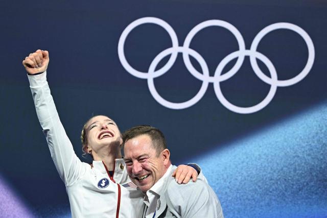 USA's Amber Glenn (L) reacts in the kiss and cry area after competing in the figure skating women's single free skating final during the Milano Cortina 2026 Winter Olympic Games at Milano Ice Skating Arena in Milan on February 19, 2026. (Photo by Gabriel BOUYS / AFP)