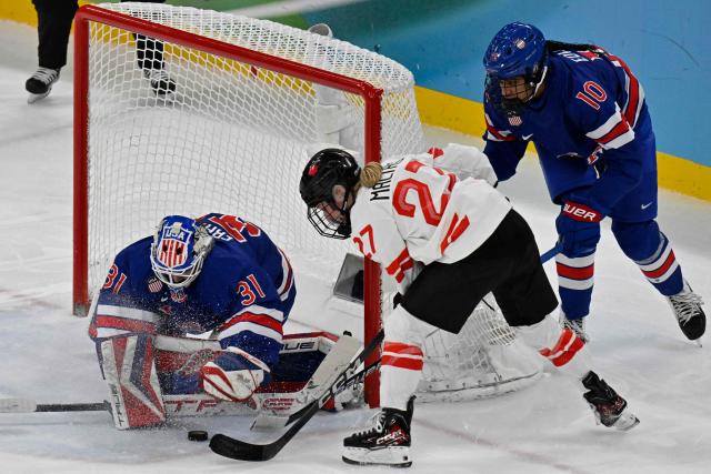 USA's #31 Aerin Frankel (L) and USA's #10 Laila Edwards (R) vie with Canada's #27 Emma Maltais (C) during the women's gold medal ice hockey match between USA and Canada at the Milano Santagiulia Ice Hockey Arena during the Milano Cortina 2026 Winter Olympic Games in Milan, on February 19, 2026. (Photo by Alexander NEMENOV / AFP)