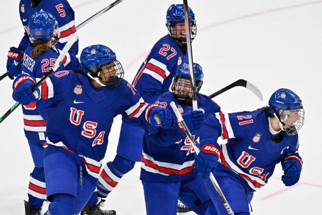 USA's #21 Hilary Knight (R) celebrates scoring her team's first goal with teammates during the women's gold medal ice hockey match between USA and Canada at the Milano Santagiulia Ice Hockey Arena during the Milano Cortina 2026 Winter Olympic Games in Milan, on February 19, 2026. (Photo by Alexander NEMENOV / AFP)