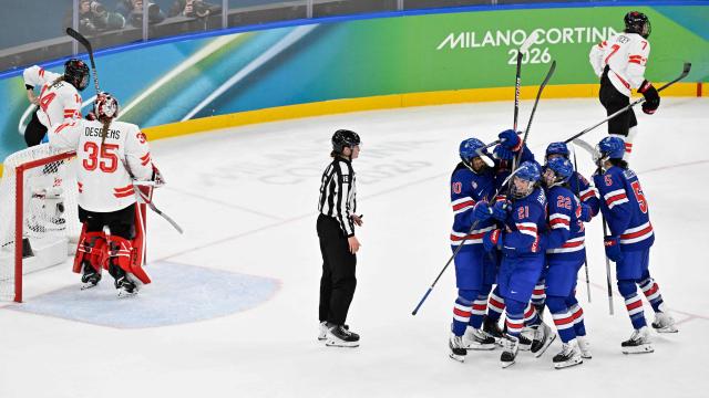 USA's #21 Hilary Knight (R-C) celebrates scoring her team's first goal with teammates as Canada's #35 Ann-Renee Desbiens (2L) reacts during the women's gold medal ice hockey match between USA and Canada at the Milano Santagiulia Ice Hockey Arena during the Milano Cortina 2026 Winter Olympic Games in Milan, on February 19, 2026. (Photo by Alexander NEMENOV / AFP)