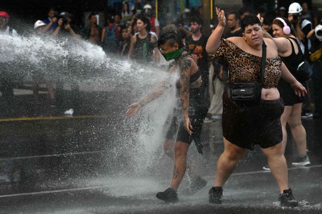 Demonstrators are sprayed with water by police outside the Congress building, where Argentina's President Javier Milei's labour reform is being treated, in Buenos Aires on February 19, 2026. The contested reforms pushed by Argentina's President Javier Milei would make it easier to hire and fire workers in a country where job security is already hard to come by. It would also reduce severance pay, limit the right to strike, increase work hours and restrict holiday provisions. (Photo by Luis ROBAYO / AFP)