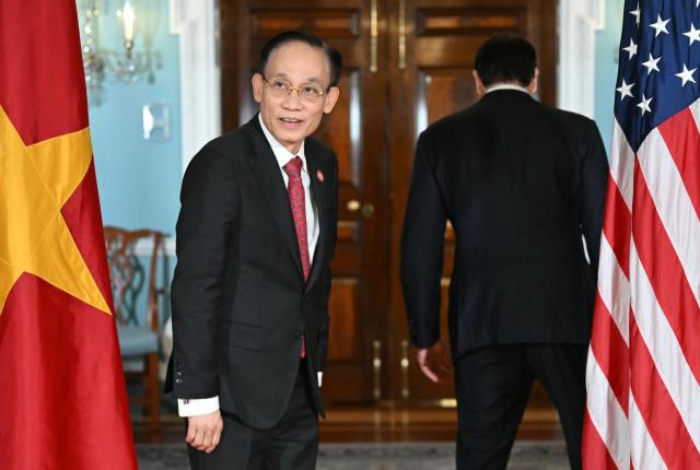 Vietnamese Foreign Minister Le Hoai Trung looks back after posing for photos with US Secretary of State Marco Rubio (R) at the State Department in Washington, DC, on February 19, 2026. (Photo by ANDREW CABALLERO-REYNOLDS / AFP)