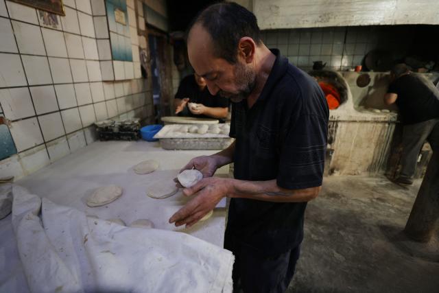 An Iraqi baker kneads the dough in a bakery during the Muslim holy fasting month of Ramadan in Baghdad on February 19, 2026. Muslims throughout the world are marking the month of Ramadan, the holiest month in the Islamic calendar, during which devotees fast from dawn until dusk. (Photo by AHMAD AL-RUBAYE / AFP)