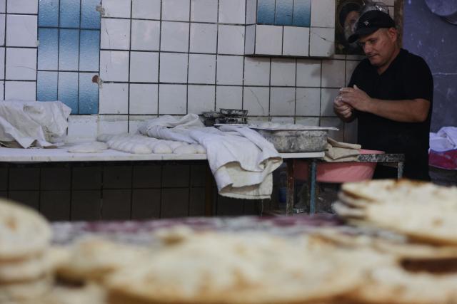 An Iraqi baker kneads the dough in a bakery during the Muslim holy fasting month of Ramadan in Baghdad on February 19, 2026. Muslims throughout the world are marking the month of Ramadan, the holiest month in the Islamic calendar, during which devotees fast from dawn until dusk. (Photo by AHMAD AL-RUBAYE / AFP)