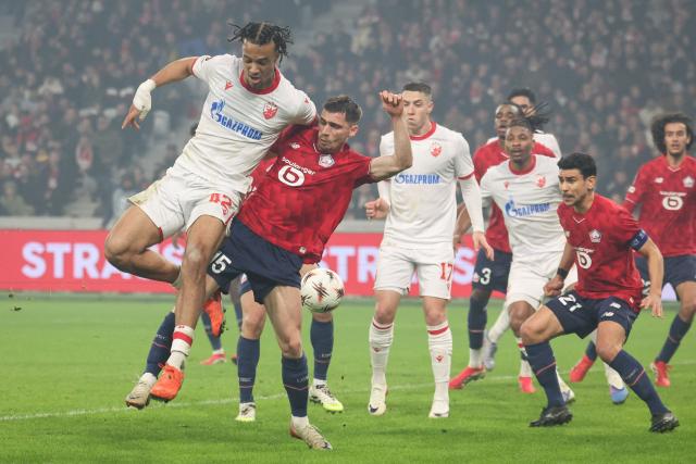 Crvena Zvezda Beograd's Dutch forward #42 Jay Enem (L) fights for the ball with Lille's French defender #15 Romain Perraud (2nd L) during the UEFA Europa League - knockout round play-off first leg - football match between LOSC Lille and FK Crvena Zvezda Beograd (Red Star Belgrade) at the Pierre Mauroy Stadium in Villeneuve d'Ascq, northern France, on February 19, 2026. (Photo by Francois LO PRESTI / AFP)